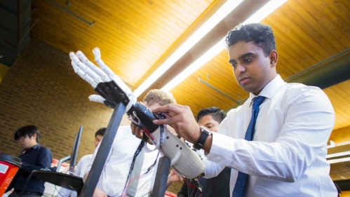 male student working on robotic hand