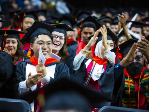 students at graduation clapping