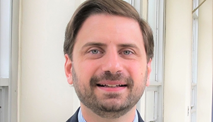 Head shot of white male with short brown hair, beard, and a moustache.