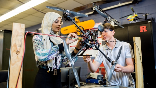 Two students working on a drone in the robotics lab