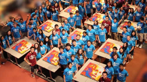 Large group of students that have solved several large Rubiks cubes