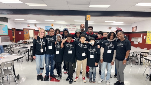 Group of middle school black male students with a teacher and two representatives from Rutgers School of Engineering. 