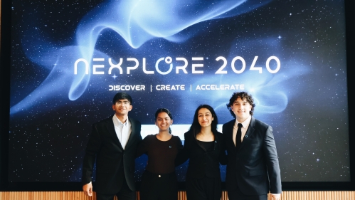 Students in professional attire pose together in front of promotional backdrop