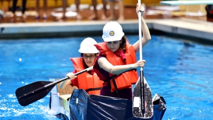 two women racing in a cardboard canoe