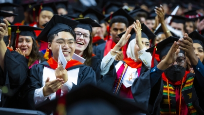 students at graduation clapping
