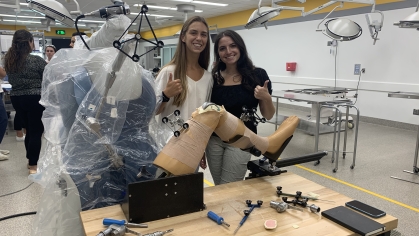 Two women in lab holding a prosthetic device