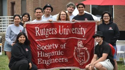 Students and their advisor holding up the Society of Hispanic Engineers banner