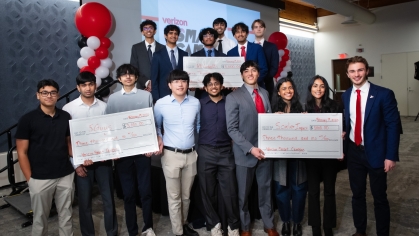 Three large group of students holding giant checks.