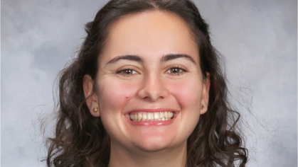 Headshot of female with shoulder length curly brown hair.