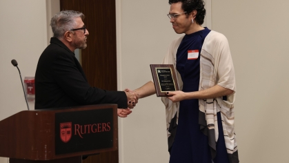 Student receiving an award and shaking hands with presenter.