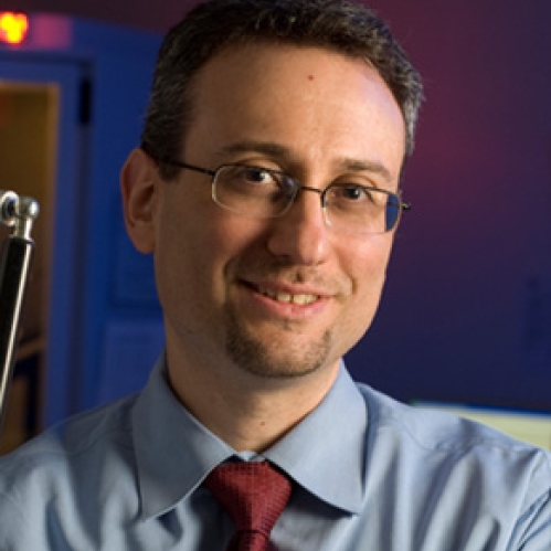 Headshot of male with eyeglasses, wearing a light blue shirt and burgundy tie.