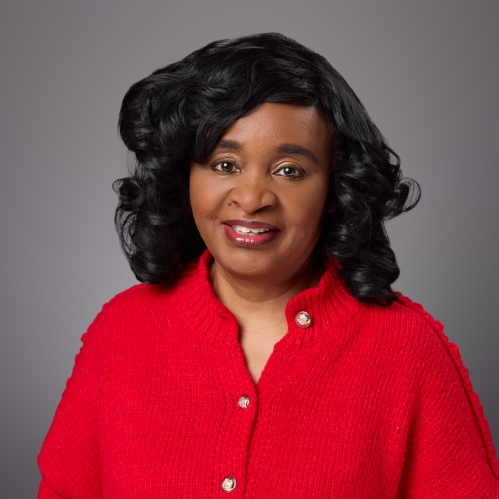 Headshot of black female with black shirt wavy hair wearing a red sweater.