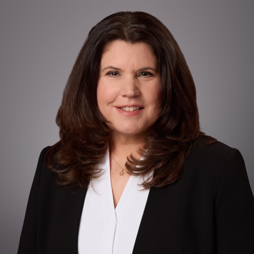 Headshot of female with long black hair wearing a white blouse under a black jacket.