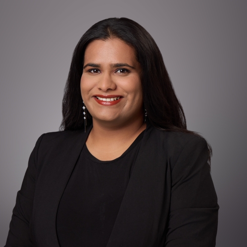 Headshot of female with long black hair wearing a black blouse under a black jacket.
