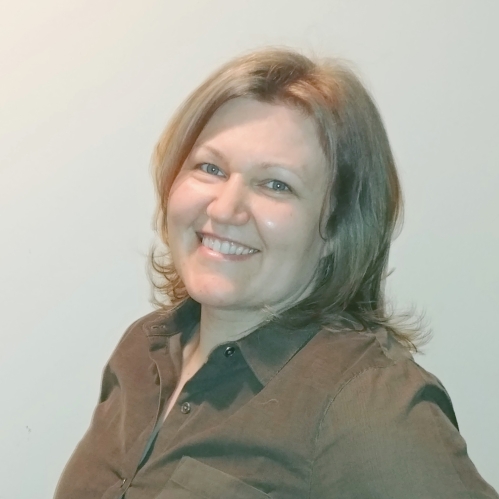 Headshot of woman with shoulder length blonde hair wearing a brown button down shirt.