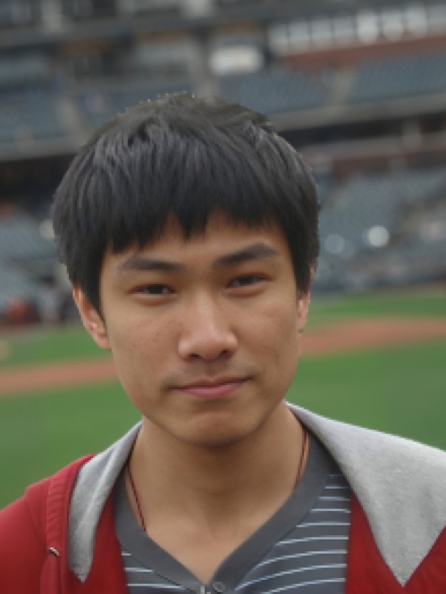 Headshot of male with black hair and bangs, wearing a grey striped shirt with a hooded grey and maroon sweatshirt.and 