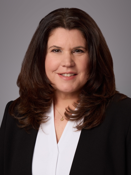 Headshot of female with long black hair wearing a white blouse under a black jacket.