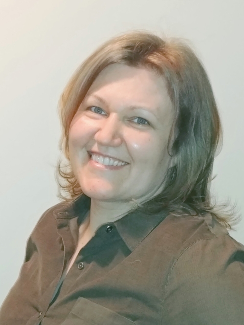 Headshot of woman with shoulder length blonde hair wearing a brown button down shirt.