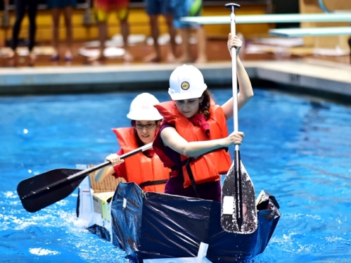 two women racing in a cardboard canoe