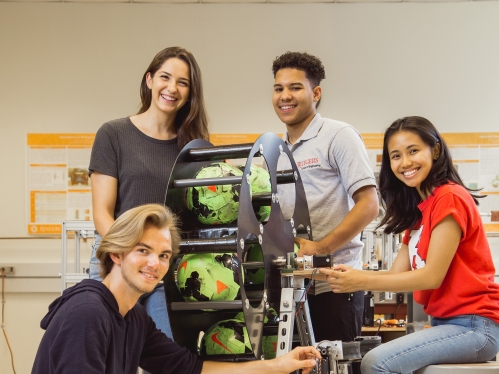 Four smiling students working in lab