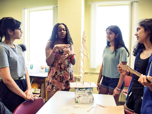 Four female students collaborating in classroom.