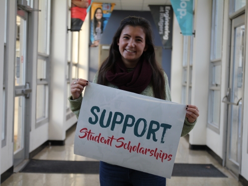 Student holding a scholarship sign
