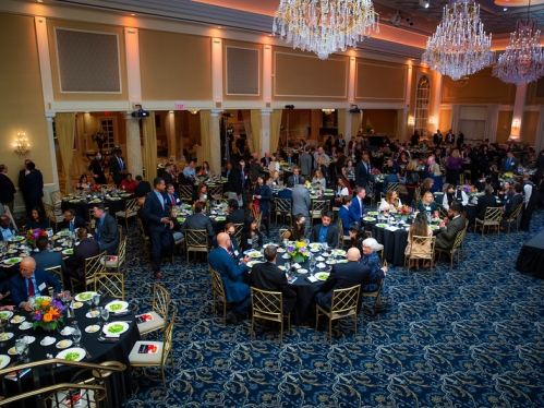 Attendees of awards dinner seated at round tables. 