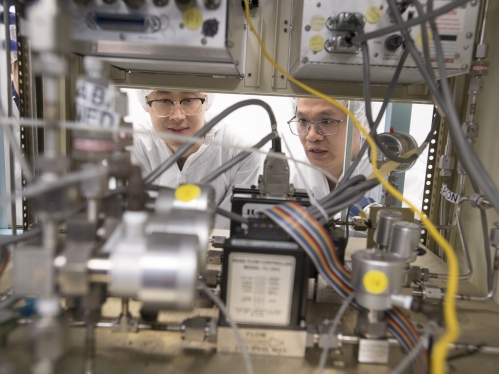 Two males wearing goggles in clean lab