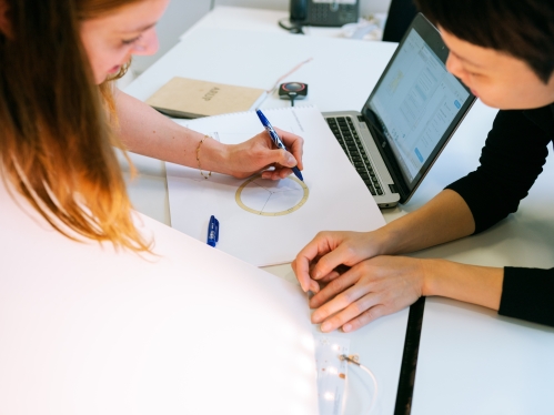 Two students at a workstation completing engineering homework