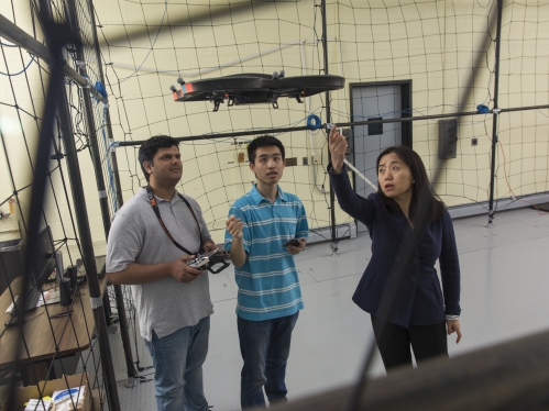 female faculty working in drone lab with two male students