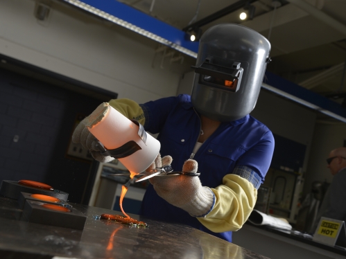 student working with melted glass in Corning lab