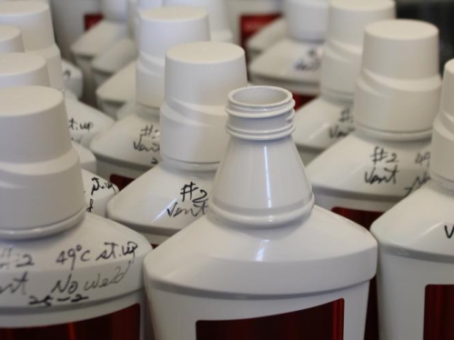 White plastic bottles with writing on them indicating experimental informations