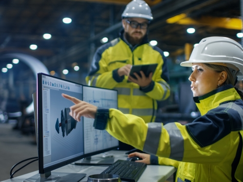 Female worker designing 3D engine with male colleague