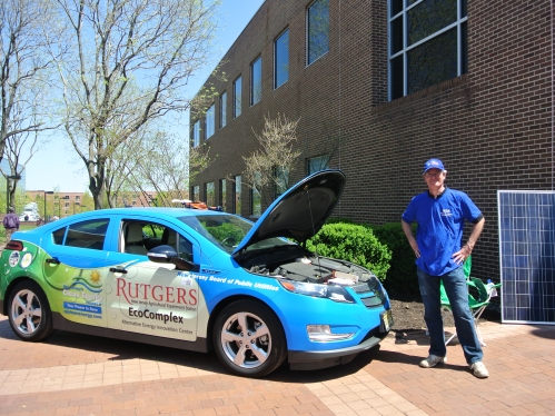 Professor standing next to rutgers solar car with hood open 