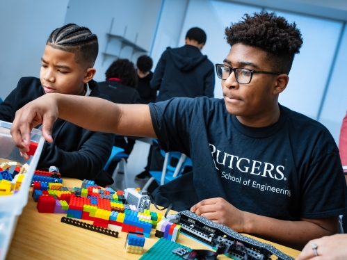 Two young black male students working on lego project.