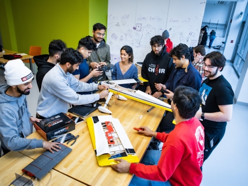 A group of ten college seniors work on project building a drone.