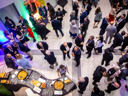 Aerial shot of large group of people during an indoor cocktail hour.
