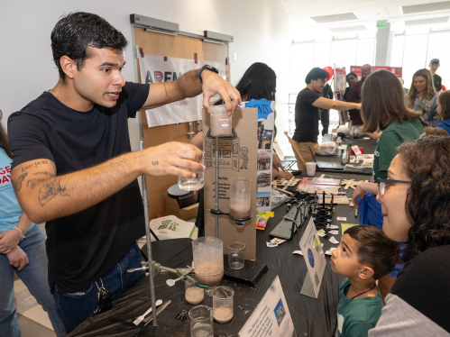 A male Rutgers School of Engineering demonstrates an experiment to family on Rutgers Day
