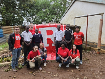 Engineers without Borders team from Rutgers pose with R banner onsite in Kenya.