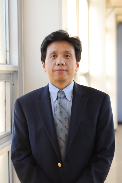 Dark haired male wearing a suit and tie.