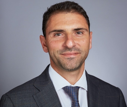 White male with short brown hair in a suit and tie.