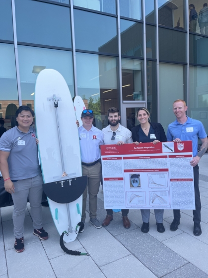 Five male and female engineering students pose with their motorized surf board project.