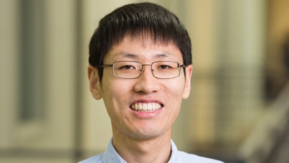 Headshot of Asian male with short black hair and bangs, wearing eyeglasses.