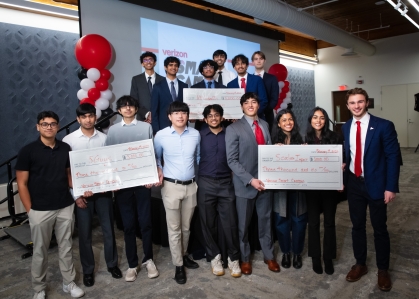 Three large group of students holding giant checks.