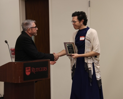 Student receiving an award and shaking hands with presenter.