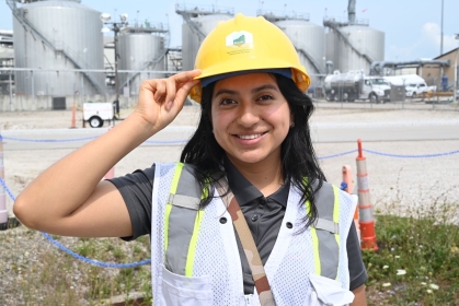 Female wearing a yellow hard hat and safety vest.