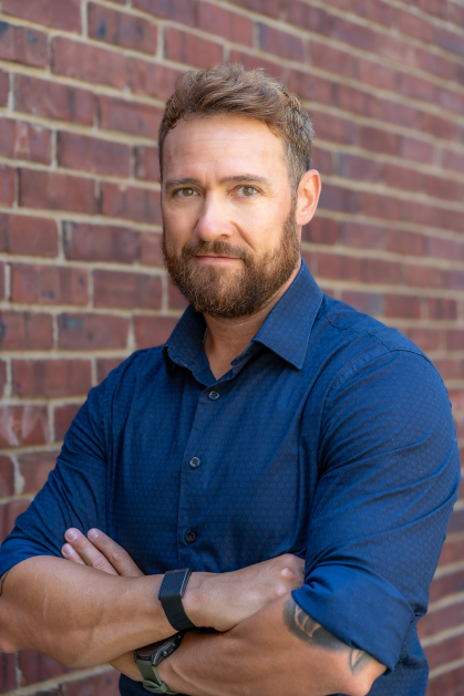 Photo of man with arms crossed wearing a blue shirt