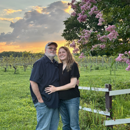 Man and woman standing in field with fence