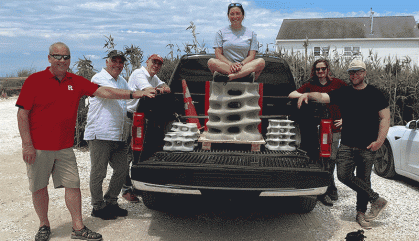 Group standing around a truck holding a concrete structure