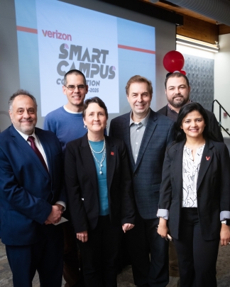 Group of six individuals standing in front of Verizon Smart Campus logo.
